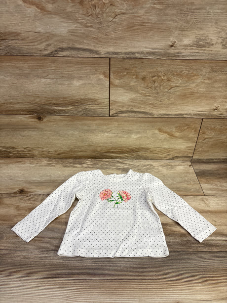 Front view of Little Me white polka dot shirt, size 18 months, showcasing long sleeves and floral embroidery on wood