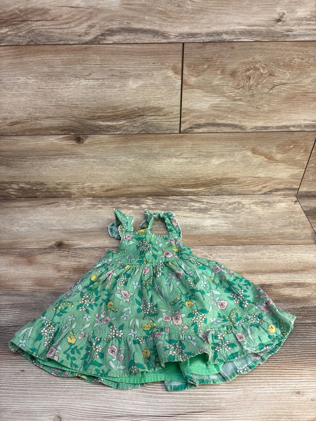 Flat lay of Cat and Jack green floral tank dress showing ruffled hem, tiered skirt and ruffled straps on wood background