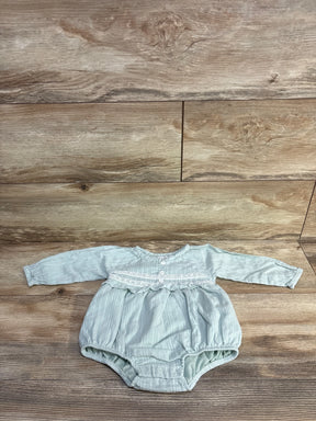 Front flat lay of green bubble romper 6-9m showing long sleeves, lace yoke and snap crotch on wood background