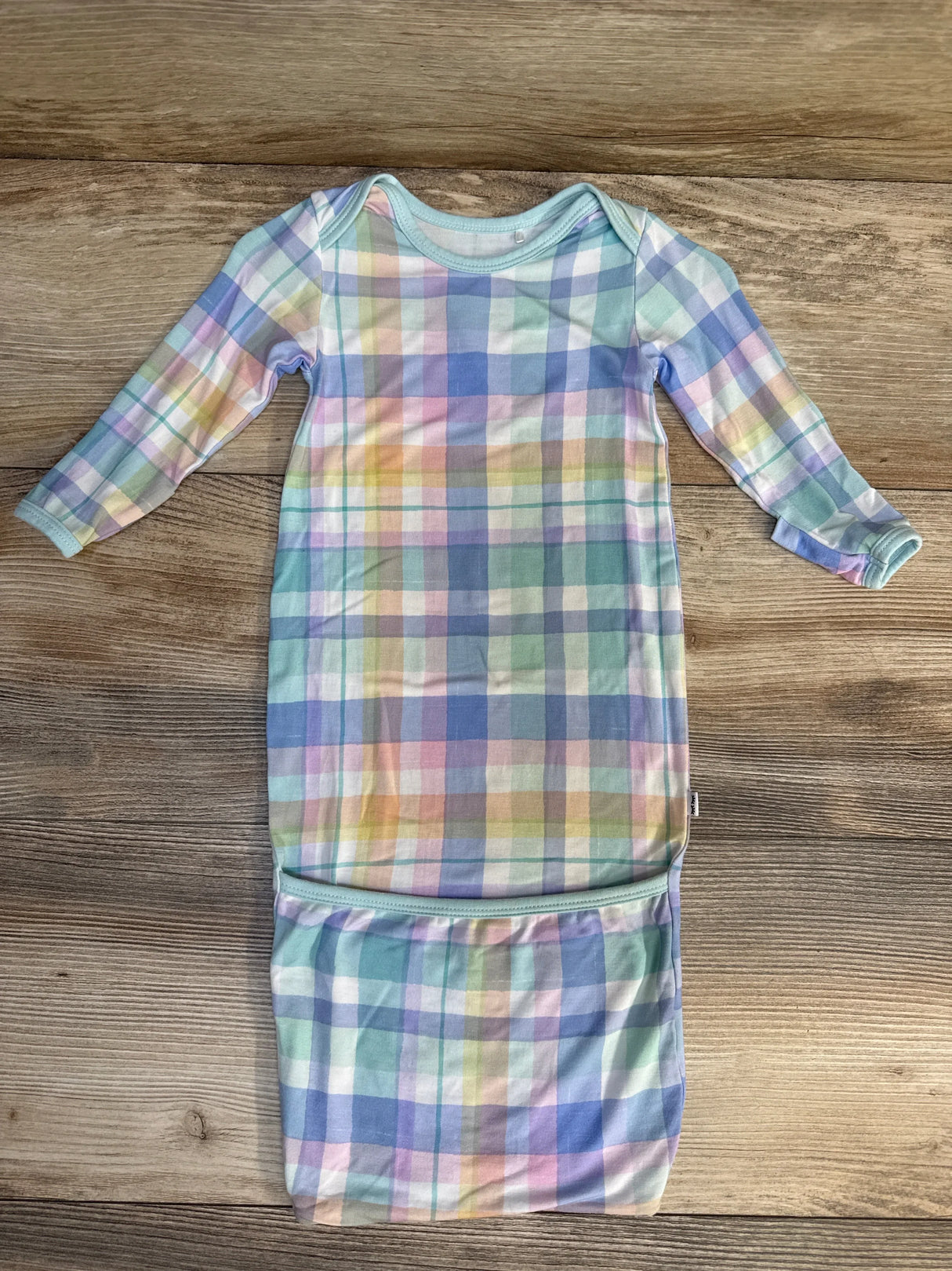 Pastel plaid long sleeve baby sleep gown on wood background