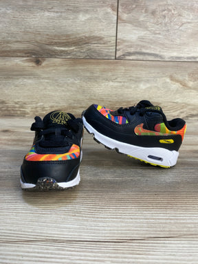 Front/side of Nike Air Max 90 TD 'Latino Heritage' sneakers, black with rainbow accents and white Air sole on wood floor