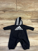 Front view of black Adidas hooded coverall in size 3 months with white logo, striped hood, zipper, and pockets on wood floor