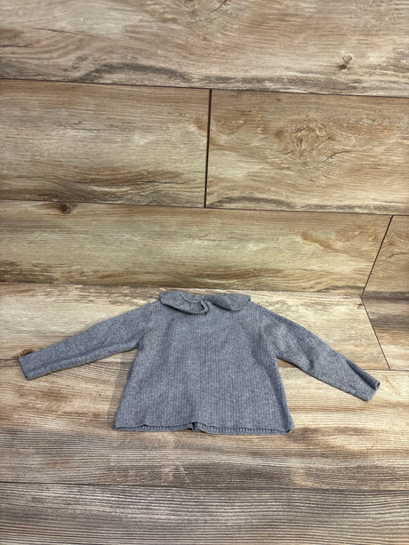 Front view of Zara grey ruffle collar sweater, size 6 to 9 months, with long sleeves and ribbed knit on wood