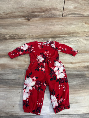 Red baby romper with long sleeves and floral print, laid flat on a wood floor