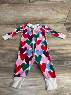 Colorful heart print baby sleeper with zipper, long sleeves, and white cuffs on wood floor