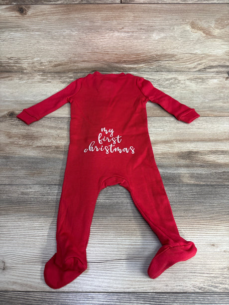 Red baby sleeper with 'my first christmas' text, footed, on wooden background
