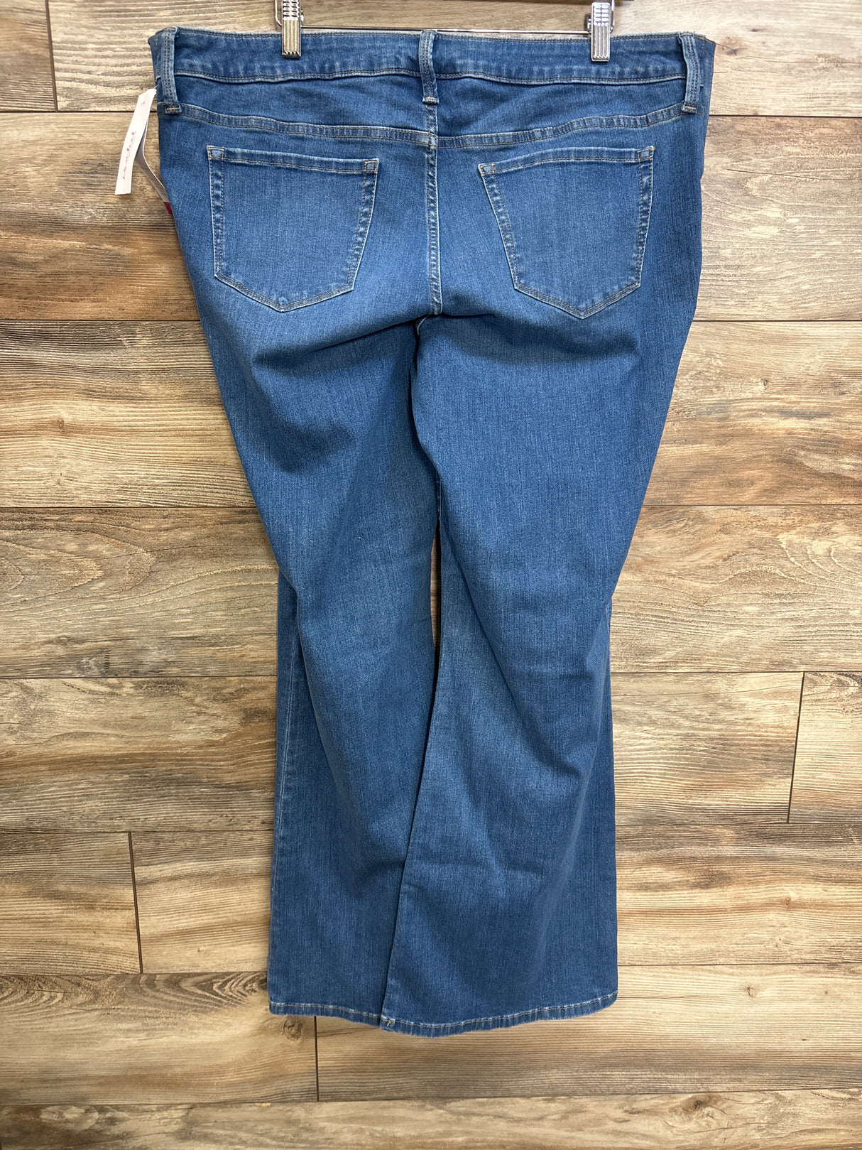 Back view of Isabel maternity flare jeans in blue, size XL, showcasing side-stretch panel and back pockets with wood floor background
