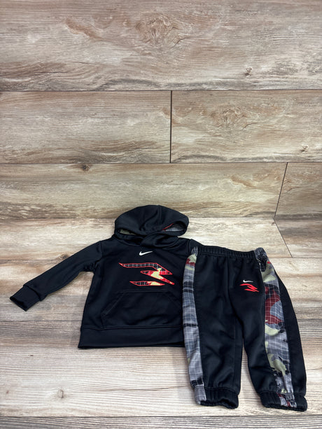 Top-down view of Nike x 3Brand black hoodie and joggers set showcasing red graphics and plaid side panels on wood flooring