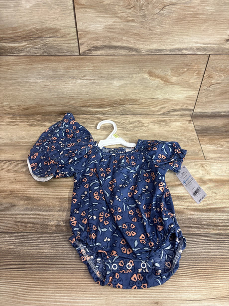 Top down view of blue floral baby bubble romper with matching bucket hat showing puff sleeves and snap crotch on wood surface