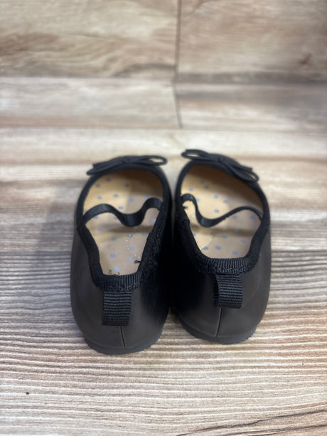 Top view of Cat & Jack Nora black ballet flats, size 7C, with bow details, elastic straps, and polka dot insoles on wood grain