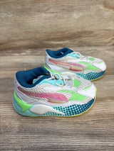 Three-quarter view of Puma RS-X3 toddler sneakers size 5C with white mesh, iridescent pink stripe and green-teal accents on wooden floor
