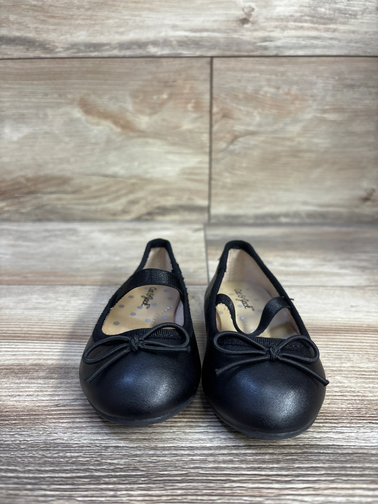 Front view of Cat & Jack Nora slip-on ballet flats size 5C showcasing elastic strap and bow detail on wood-look floor background