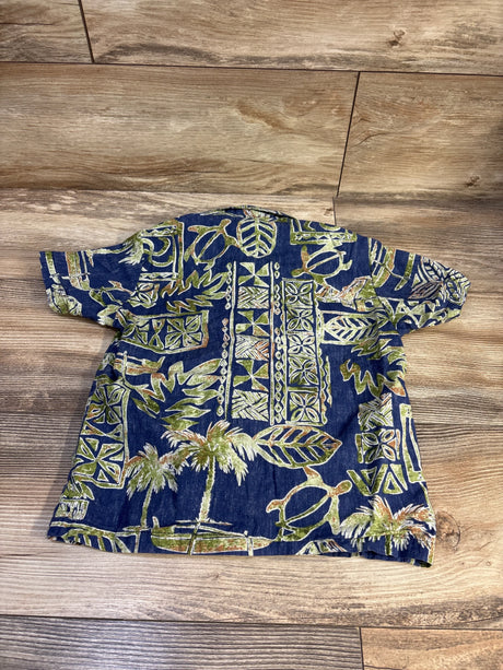 Back view of Bishop St. Hawaiian toddler short sleeve shirt showing green and beige tropical print on blue fabric on wood floor