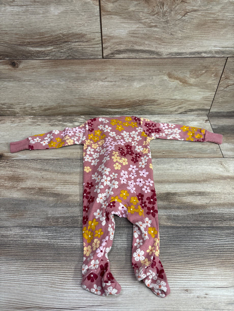Front view of Member’s Mark pink floral footed sleeper in size 3m with long sleeves and enclosed feet on a wood-grain background