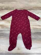 Front view of a Just One You floral sleeper in red with long sleeves and covered feet on a wood-grain background