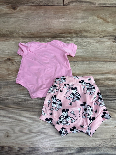 Top view of pink Disney Mickey Mouse bodysuit and matching character print shorts set for 0 to 3 months on woodgrain