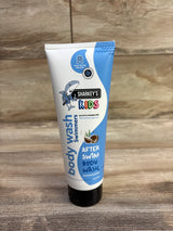 Front view of Sharkey's Kids After Swim body wash tube (6 oz) showing shark logo and blue and white packaging on wooden surface