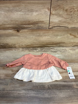 Baby girl long sleeve pink and white dress displayed on wood floor with price tag attached