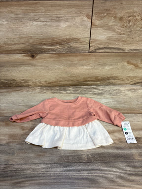 Baby girl long sleeve pink and white dress displayed on wood floor with price tag attached