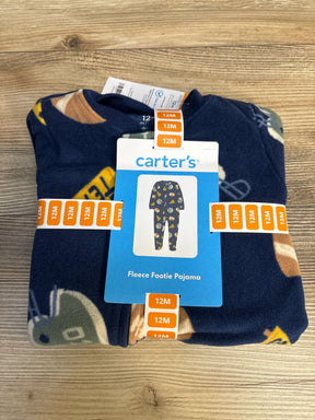 Folded Carter's fleece footie pajamas, 12 months, navy blue with sports pattern, on wood surface