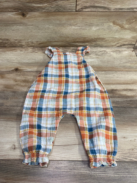 Flat lay of Angel Dear plaid smocked sleeveless jumpsuit in orange, blue, and cream, size 12 to 18 months, on wood