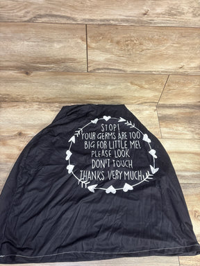 Black baby car seat cover with white text 'Stop! Your germs are too big for little me!' on wood floor
