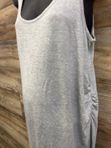 Close-up front view of grey maternity ruched tank dress showcasing side ruching on a mannequin against wood plank background