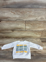 White long-sleeve kids sweatshirt with 'Birthday Boy' text in green and yellow on wood floor