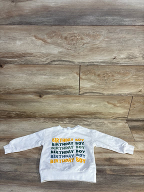 White long-sleeve kids sweatshirt with 'Birthday Boy' text in green and yellow on wood floor