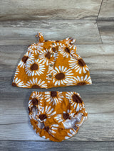 Flat lay of Carter's two-piece sunflower top and matching shorts showing front buttons and elastic-waist bloomers on wood floor, size 3M