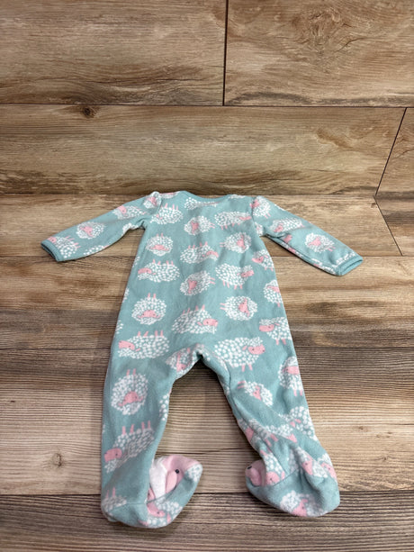 Front view of a blue long-sleeve footed baby sleeper showcasing a pink and white hedgehog print with a wood-grain background