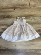 Flat-lay of Goodlad 2T embroidered giraffe gingham dress with smocked bodice, tie straps, pastel stripes on wood background