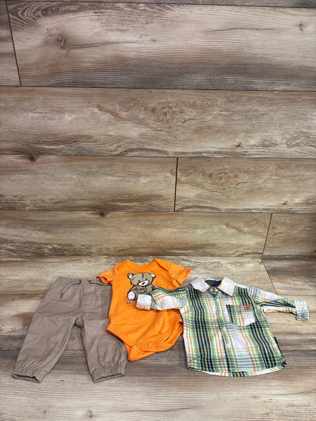 Top-down view of American Hawk 3-piece baby set with plaid shirt, orange bodysuit, and gray pants on wood flooring