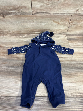 Navy blue baby onesie with hood and patterned white stars and trees on sleeves and hood, laid on wooden floor