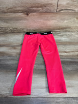 Flat lay back view of girls Nike Dri-Fit leggings size 4T showing black elastic waistband with repeating Nike logo and white swoosh on wood floor
