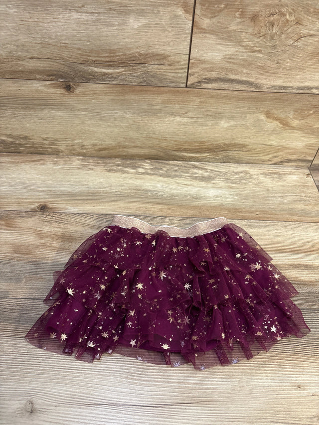Jumping Beans layered purple tulle skirt with gold star glitter accents on a wood background