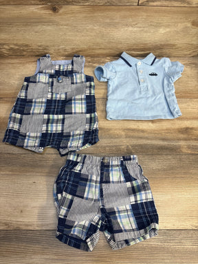 Baby boy plaid shorts, matching romper, and light blue polo shirt laid on wood floor