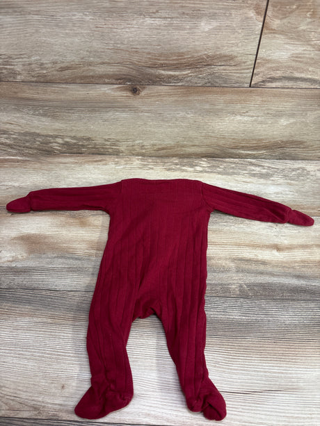 Full view of Member’s Mark red ribbed sleeper in size 3 months with long sleeves and covered feet on a wood-look background