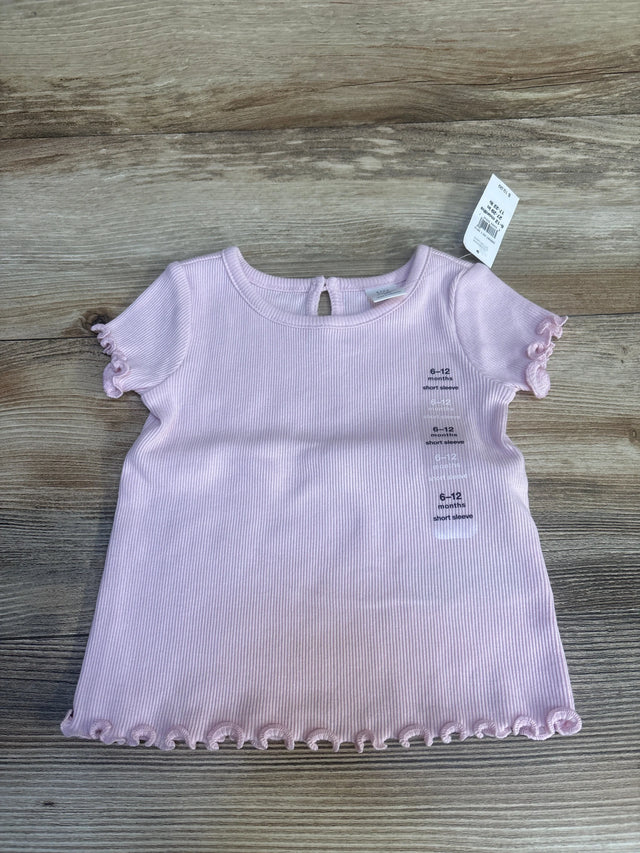 Light pink baby short sleeve shirt with ruffled hems, size 6-12 months, on wood background