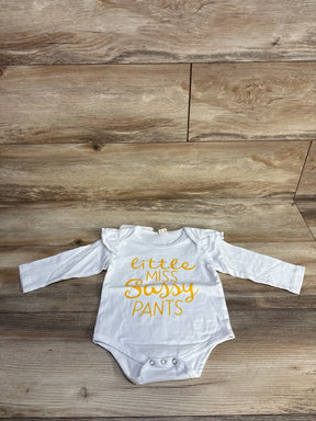 White baby bodysuit with yellow 'Little Miss Sassy Pants' text on wood floor