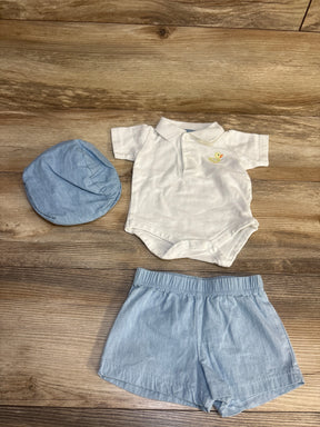 Baby boy outfit with blue shorts, white bodysuit, and matching blue cap on wood background
