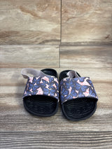 Front view of Nike Kawa Slide SE toddler sandals showcasing pink butterfly strap and black contoured soles on wood-look floor