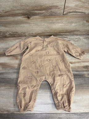 Beige baby romper with long sleeves and brown baseball print, laid flat on wood floor