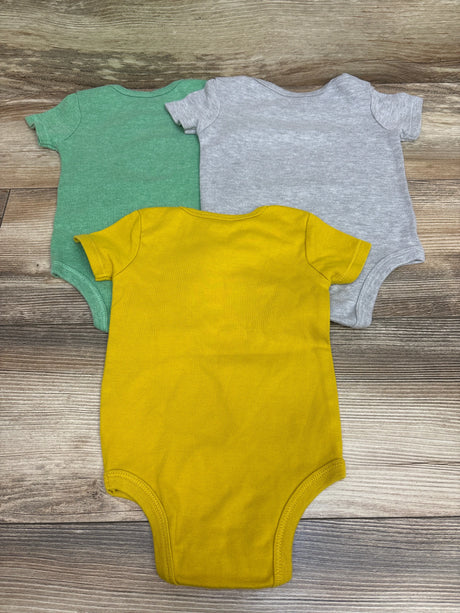 Top view of Star Wars 3pk baby bodysuits in green, gray, and yellow laid flat on a wood-grain surface