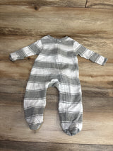 Gray and white striped long-sleeve baby footed onesie lying flat on wooden floor