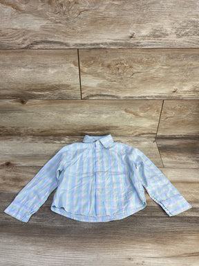 Flat lay of toddler Tommy Hilfiger blue plaid button-up shirt with collar and chest pocket on wood background
