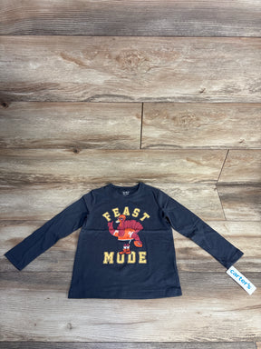 Kids black long-sleeve shirt with cartoon turkey and text Feast Mode on wooden floor