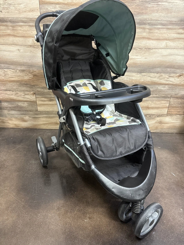 Front three-quarter view of Baby Trend EZ Ride Stroller in Doodle Dots showcasing canopy, tray, and storage basket on a wood plank floor