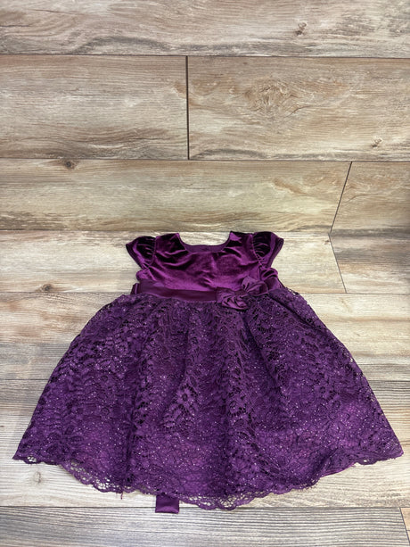 Front view of Jona Michelle purple velvet lace dress in size 3T with flutter sleeves, waist bow, and scalloped lace hem on wood
