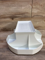 Front view of Dexbaby The Spin changing station, white, round divided storage compartments and removable top on wood